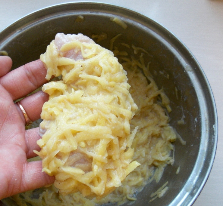 1. Этап. Куриное филе в картофельной шубке: Возьмите кусочек филе и обваляйте его в картофельной массе, прижимая картофель пальцами.