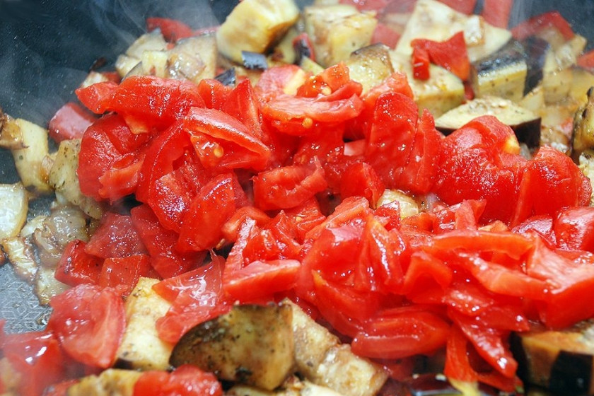 1. Этап. Подлива из баклажан: Добавить нарезанные помидор и чеснок. Посолить, но не сильно, так как баклажан уже содержит немного соли. Солить по вкусу и осторожно. Лучше потом добавить соли и поперчить — в самом конце. Добавить все специи, в т.ч. — 0.5 ч.л. сахара и 1-2 щепотки ароматных сухих трав: базилик, укроп, орегано, тимьян и т.д.