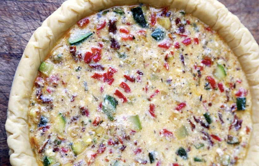 1. Этап. Солёная домашняя выпечка: Затем к яично-сырной смеси добавьте овощи. Еще раз все перемешайте. Слоеное тесто раскатайте и выложите в форму для запекания. Диаметр моей формы — 22 см. На тесто выложите начинку.