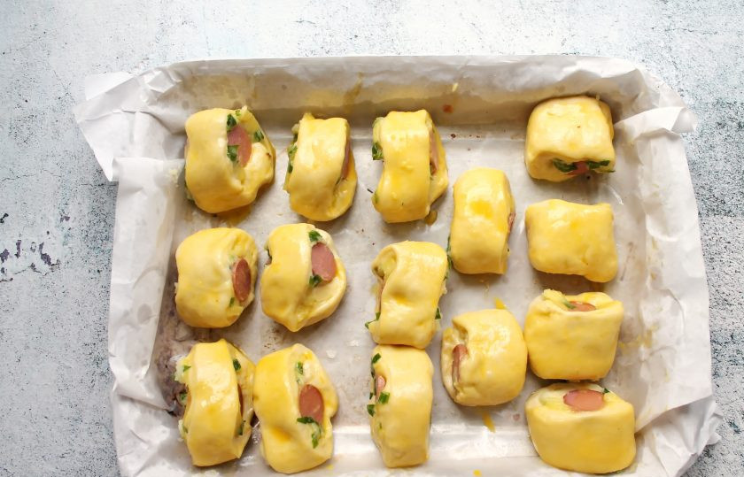 1. Этап. Пирожки Два в одном: Противень застелите пергаментом и смажьте растительным маслом. Выложите пирожки на расстоянии швом вниз. Накройте и дайте постоять 15 минут для подъема. Смажьте верх яйцом или молоком.