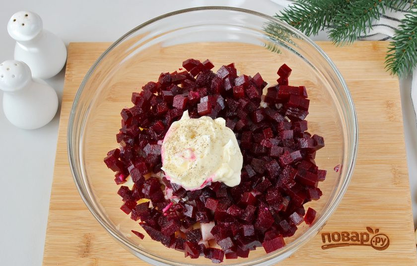 1. Этап. Салат Тигр в шубе на Новый год: Свеклу очистите, порежьте кубиками, выложите в салатник. Добавьте 2-3 ложки майонеза, соль и черный перец.