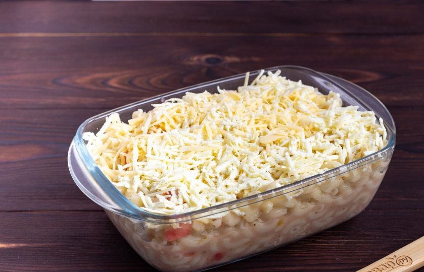 1. Этап. Паста с козьим сыром и помидорами: Форму смажьте растительным маслом и выложите в нее пасту. Сверху посыпьте оставшимся сыром.