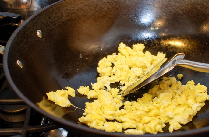 1. Этап. Лапша по-сингапурски: В воке разогреваем масло. Обжариваем 10 секунд яйца, перемешивая их лопаткой, чтобы они разделились на кусочки.