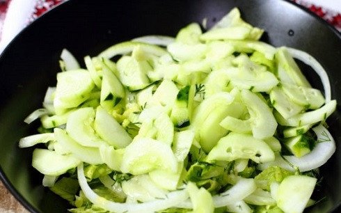 1. Этап. Салат из куринной грудки: Огурцы нарезаем тонкими полукольцами и выкладываем в тарелку. Поливаем заправкой.