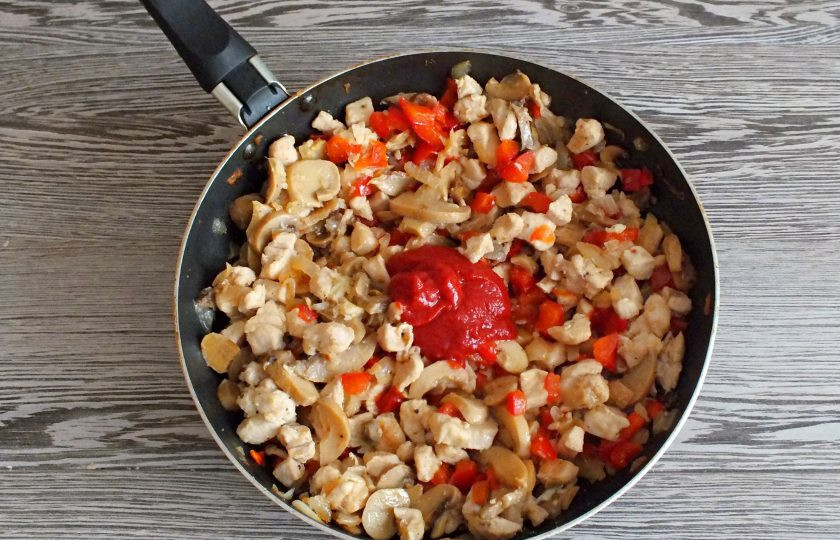 1. Этап. Энчиладос с курицей в лаваше: Добавьте 1 ст.л. томатной пасты, измельченный чеснок. Перемешайте. Прогрейте в течение 3-4 минут.