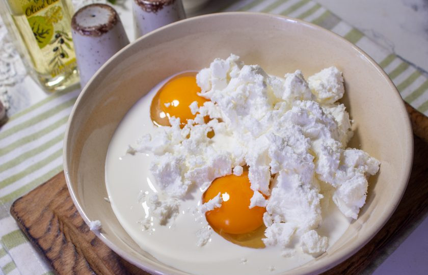1. Этап. Спанакопита: Отдельно смешайте куриные яйца, сливки и раскрошенную фету.