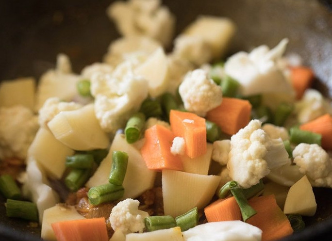 1. Этап. Тушеный микс овощей: 3. Выложите цветную капусту, разделенную на соцветия, нарезанный картофель, морковь, фасоль.