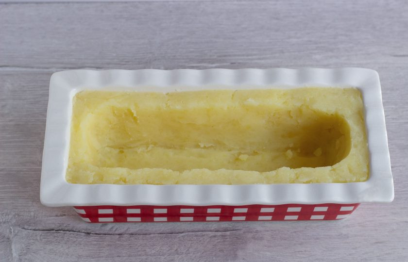 1. Этап. Картофельно-морковная запеканка с брокколи: Силиконовую или керамическую форму смажьте растительным маслом и выложите пюре, формируя бортики. Сделайте углубление.