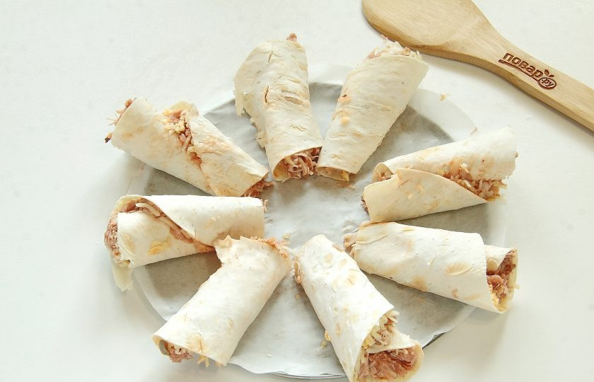 1. Этап. Закуска Цветущее кольцо Кесадильи: Сверните каждую кулечком и уложите в круг из 8 штук на круглую форму для запекания, застеленную пергаментом. Я использовала дно от разъемной формы. По центру оставьте место для соуса.