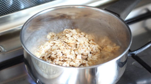 1. Этап. Каша на воде с сухофруктами: Засыпьте овсянку. Снимите кастрюльку с огня. Хлопья не обязательно варить, ведь их можно запарить.