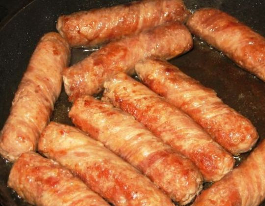 1. Этап. Чевапчичи в беконе: Разогреваем сковороду с растительным маслом и обжариваем на среднем огне чевапчичи со всех сторон до красивой румяной корочки.
