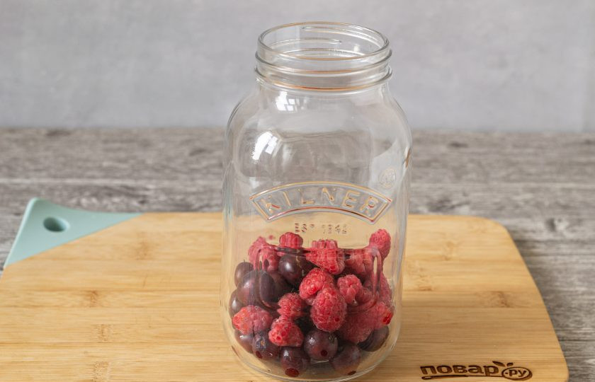 1. Этап. Компот из крыжовника с малиной: Выложите ягоды в чистую стерилизованную банку.