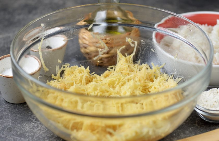 1. Этап. Рисовые драники: Натрите картофель на мелкой терке, отожмите всю жидкость, переложите стружку в глубокую миску.