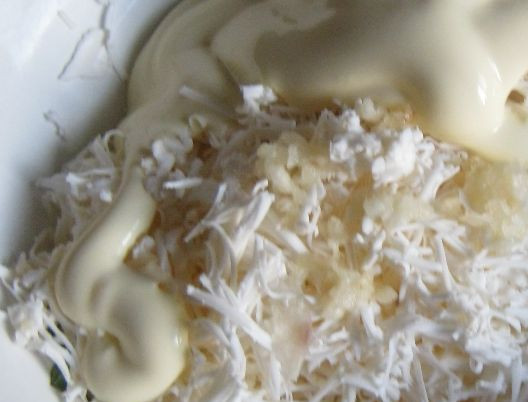 1. Этап. Рулет из омлета: 3. Натираем сыр, добавляем чеснок и майонез. Хорошо перемешиваем до однородной консистенции. Тем временем омлет уже готов. Вынимаем противень из духовки, и даем немного остыть омлету, после чего аккуратно перекладываем его на стол.