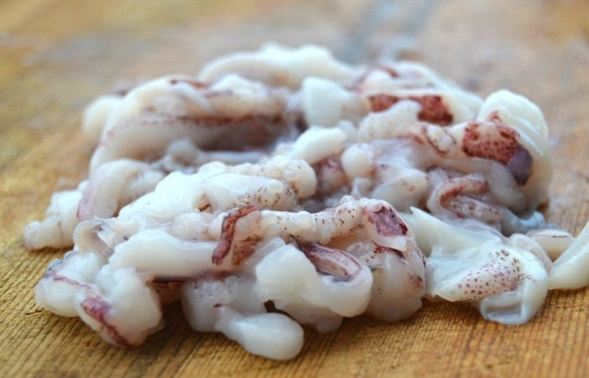 1. Этап. Запеченный фаршированный кальмар: 1. Используйте щупальца осьминога. Очистите их от кожи и нарежьте небольшими кусочками.