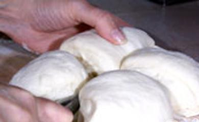 1. Этап. Багеты с зеленью: 4. Зелень добавляем в хлебопечку после того, как услышим первый сигнал. Тесто достаем из контейнера после того, как услышим второй сигнал. Доску немного припудрим мукой, выложим на нее тесто и на четыре части его разделяем.