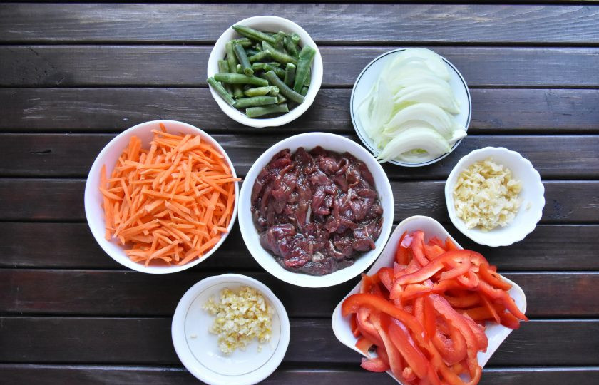 1. Этап. Удон с говядиной в устричном соусе: Подготовьте овощи. Чеснок и имбирь измельчите. Морковь, репчатый лук и болгарский перец нарежьте соломкой.