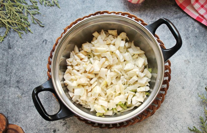 1. Этап. Суп из фенхеля и сельдерея: У фенхеля отрежьте донышко, разрежьте пополам и отрежьте жесткую середку. Порежьте фенхель мелкими кусочками и добавьте в кастрюлю с овощами. Обжаривайте все в течение 5 минут, перемешивая.