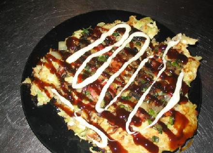 1. Этап. Японская пицца Окономияки (Okonomiyaki): Выкладываем блюдо на широкую тарелку и щедро поливаем соусом Okonomiyaki и майонезом.