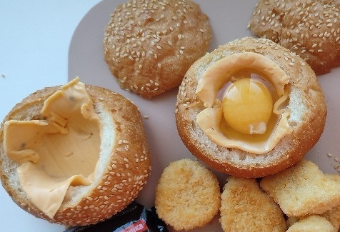 1. Этап. Горячие бургеры с наггетсами: Аккуратно разбиваем в каждую булочку яйцо.