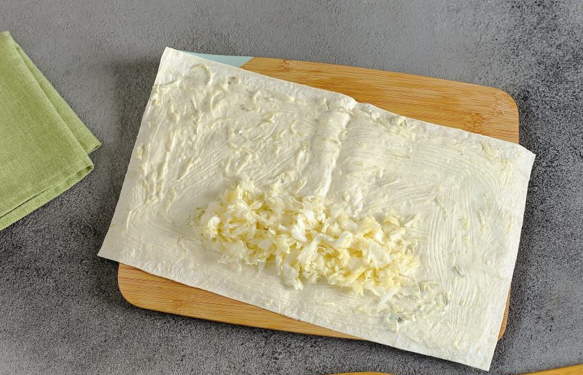 1. Этап. Фишролл: Лаваш разрежьте пополам и смажьте соусом. Пекинскую капусту тонко нашинкуйте, помните руками и выложите на лаваш.