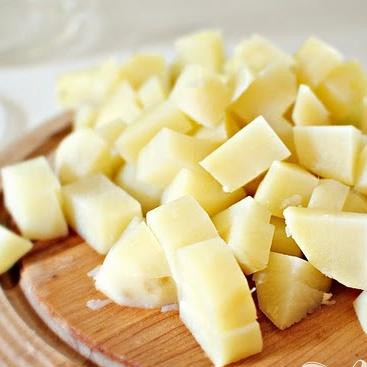 1. Этап. Картофель с беконом: 2. Очищенный картофель разрезать пополам и поместить в большую кастрюлю с водой, чтобы вода полностью покрывала картофель. Довести до кипения на среднем огне, затем снизить огонь до медленного и варить от 10 до 12 минут. Слить воду, откинув картофель на дуршлаг, и залить холодной водой. Остывший картофель нарезать кубиками размером 1 см.