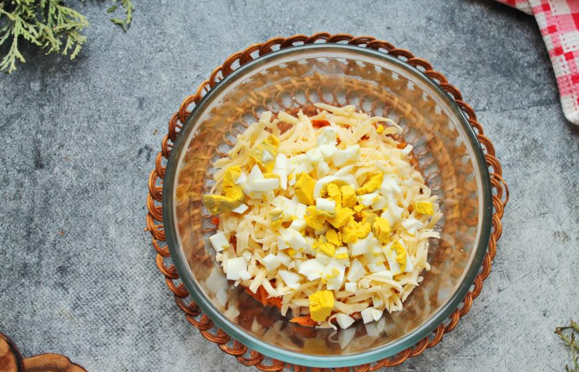 1. Этап. Салат с сыром, кукурузой и морковью: Яйцо порежьте кубиком и добавьте в салат.
