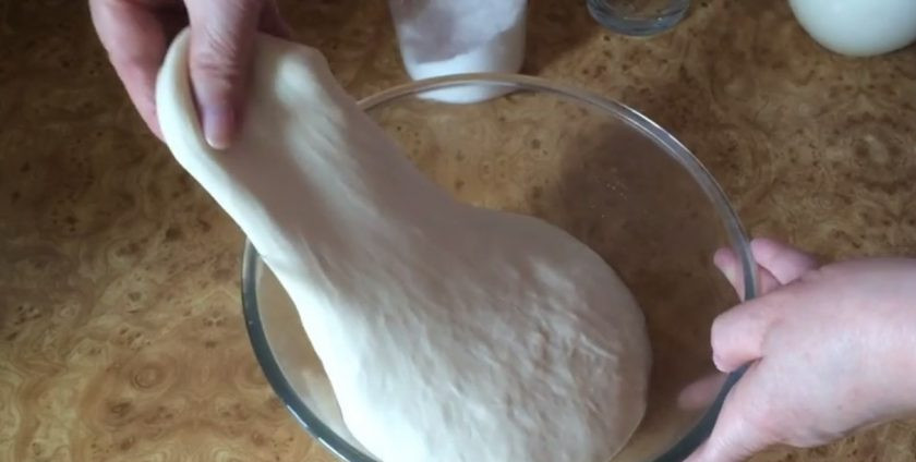 1. Этап. Хлеб оливковый на закваске: 4. Переверните тесто, накройте пленкой и оставьте на 3-4 часа при комнатной температуре. Растяните тесто, взяв один его край, вытянув его как можно больше и сложив его к противоположной стороне миски.