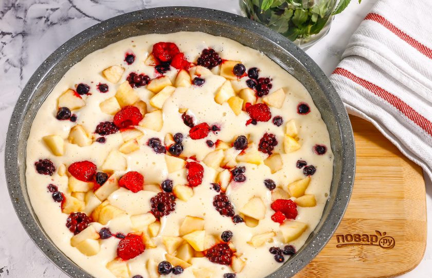 1. Этап. Пирог с яблоками и ягодами: Смажьте форму для запекания растительным маслом, выложите в нее бисквитное тесто. В тесто выложите яблочную нарезку и ягоды вразброс. Поместите форму в духовку на 25 минут до румяности.