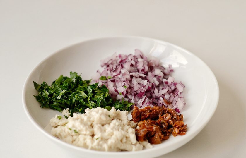 1. Этап. Томатные котлеты: Лук мелко нарежьте или натрите на крупной терке. Фету раскрошите, мяту мелко порубите. Вяленые томаты тоже измельчите максимально мелко.