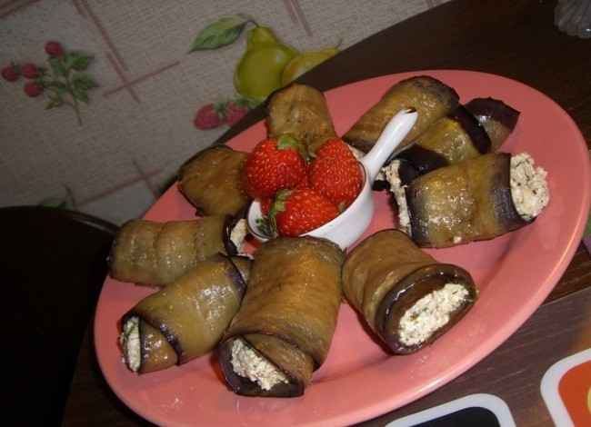 1. Этап. Баклажан с творожным сыром: 4. На каждую полосочку баклажана выложите немного творожной массы (распределите её равномерно между всеми полосками), сверните полоски баклажанов с сыром в рулетики. Выложите на блюдо швом вниз. Баклажан с творожным сыром готов! Приятного аппетита!