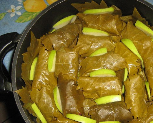 1. Этап. Долма азербайджанская: 7. Возьмите казанок и на его дно выложите листья винограда. Переложите в казанок долму. Нарежьте кусочки яблока и уложите их между каждой штучкой долмы. Также поступите с последующими слоями.