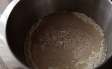 1. Этап. Хлеб с сухофруктами и орехами: Добавляем к муке соль и разведенные дрожжи. И замешиваем тесто.