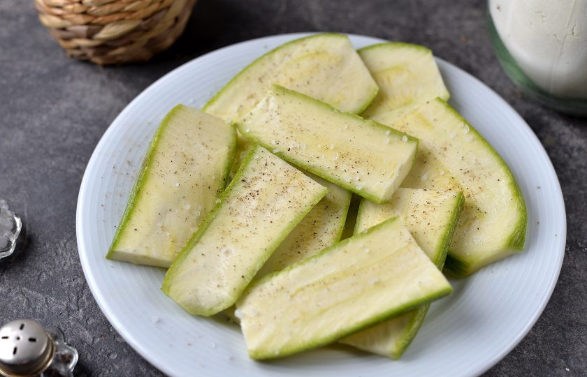 1. Этап. Сэндвичи из кабачков с сыром: Кабачок нарежьте ломтиками 3 миллиметра толщиной, каждый ломоть разрежьте пополам, посолите и поперчите по вкусу.