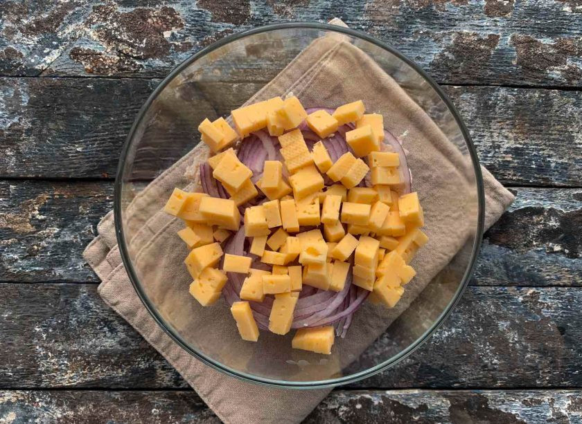 1. Этап. Салат из стручковой фасоли с мясом: Сыр нарежьте кубиками или натрите на крупной терке и выложите в тарелку.