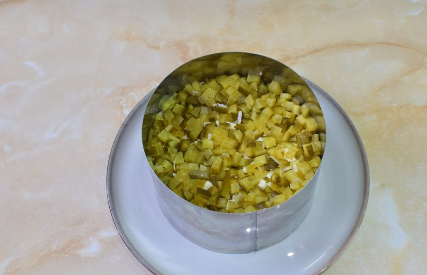 1. Этап. Салат Дубок с курицей и шампиньонами: Маринованные грибы мелко нарежьте. Если их натереть на терке, то они пустят сок и испортят внешний вид салата. Выложите слой из огурцов.