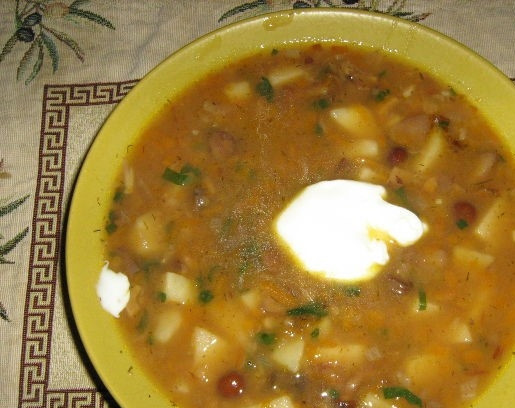 1. Этап. Суп из чечевицы с грибами: 4. Очистите картофель, порежьте его на небольшие кусочки, добавьте в суп. Всыпьте чечевицу. Варите до готовности минут двадцать. Порежьте мелко зелень, добавьте в жидкость. Мелко подробите чеснок. Всыпьте в суп. Оставьте суп с чечевицей и грибами настаиваться и пропитываться запахами и вкусами на десять минут. Подавайте суп в тарелочках с небольшим островком сметаны. Приятного аппетита!