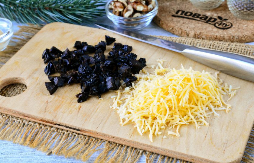 1. Этап. Салат Зимняя сказка: Твердый сыр натрите на терке. Чернослив промойте в теплой воде, просушите и нарежьте соломкой или небольшими кусочками.