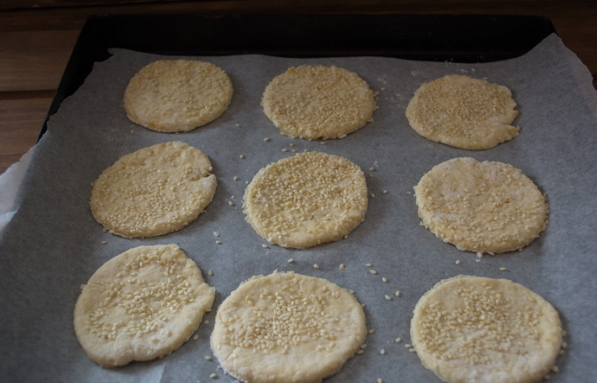 1. Этап. Печенье на сметане с кунжутом: Стаканом вырежьте из теста кружки. Уложите их на противень. Разогрейте духовку до 200 градусов и выпекайте печенье в духовке 15 минут.