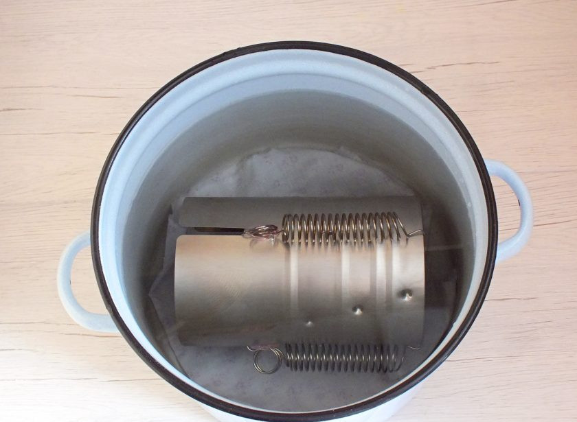 1. Этап. Буженина в ветчиннице: Возьмите большую кастрюлю. На дно выложите ткань. Положите на бок ветчинницу и залейте водой так, чтобы ветчинница полностью была покрыта жидкостью. Поставьте на средний огонь, доведите до кипения и убавьте огонь до малого. Варите 1 час 30 минут. По истечении времени выключите огонь, слейте воду.