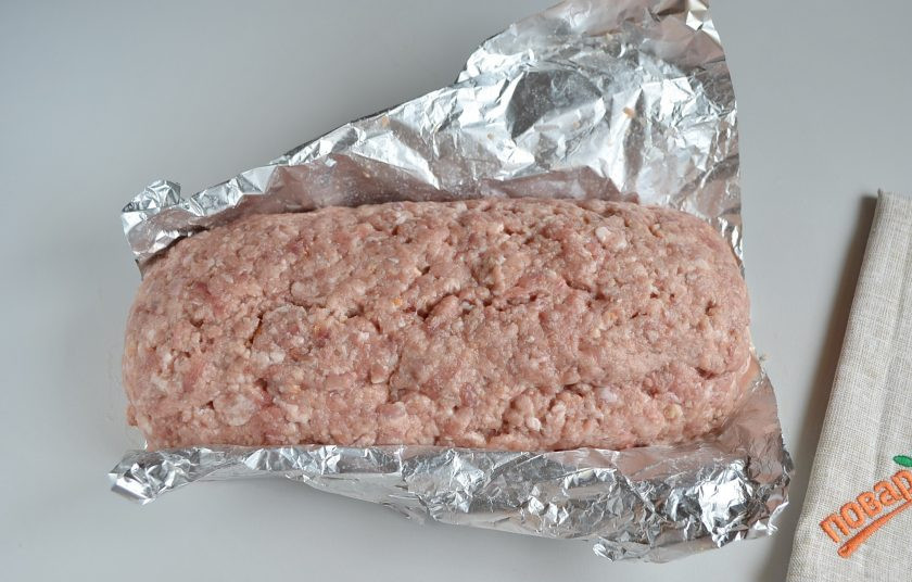 1. Этап. Мясной рулет с яйцом, как в садике: 8. Помогая себе фольгой, сформируйте рулет. Сначала накройте одной стороной фарша начинку, потом другой. Переверните швом вниз.