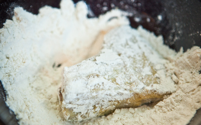 1. Этап. Камбала под маринадом: Разогреваем масло на сковороде. В миску насыпьте муку. Обваляйте рыбу в муке и выложите на сковороду.