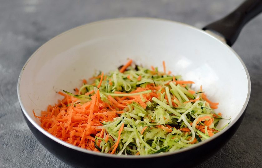 1. Этап. Гречневая лапша с ореховым соусом: Натрите цукини и морковь на терке для корейской моркови. Добавьте к грибам и жарьте примерно 5-6 минут все вместе.