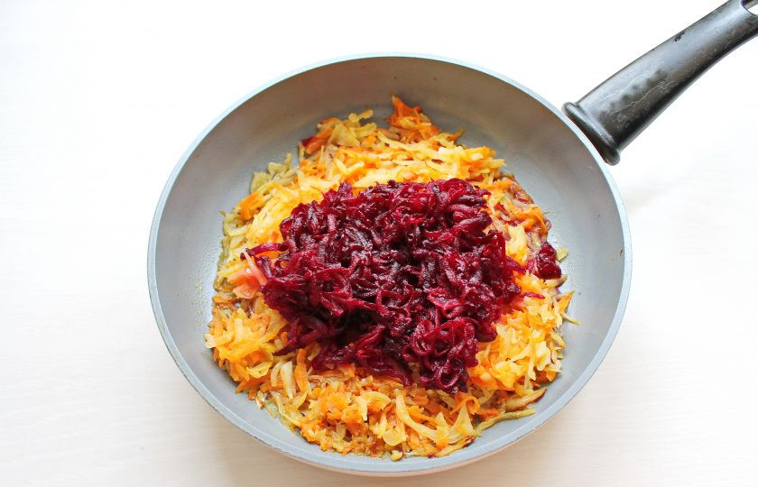 1. Этап. Украинский борщ с квашеной капустой: Свеклу вымойте, очистите и натрите на крупной терке. Выложите ее в сковороду с овощами.