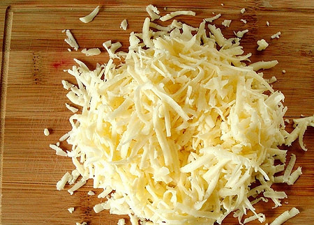 1. Этап. Луковый пирог из слоеного теста: Сыр натираем на крупной терке. По количеству: берем на свое усмотрение. Если хотите более насыщенную начинку, то тогда можно натереть сыра побольше - граммов 200.