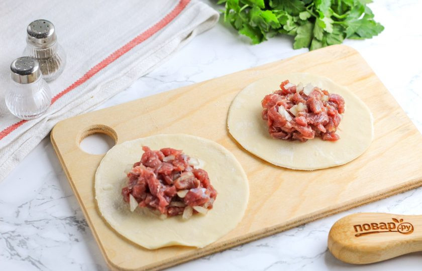 1. Этап. Манты с фаршем из говядины с бараниной: Отдохнувшее тесто раскатайте в округлый тонкий пласт, подпыляя рабочую поверхность мукой. Вырежьте с помощью пиалы или чашки с широким горлышком круги, выложите на них 1,5 ст.л. фарша.