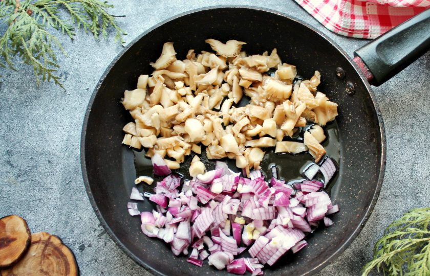 1. Этап. Куриный рулет с грибами, беконом и сыром: Грибы и репчатый лук мелко порежьте, выложите в сковороду с растительным маслом. Посолите и обжаривайте все на среднем огне в течение 10-12 минут до выпаривания жидкости. Снимите с огня и дайте остыть.