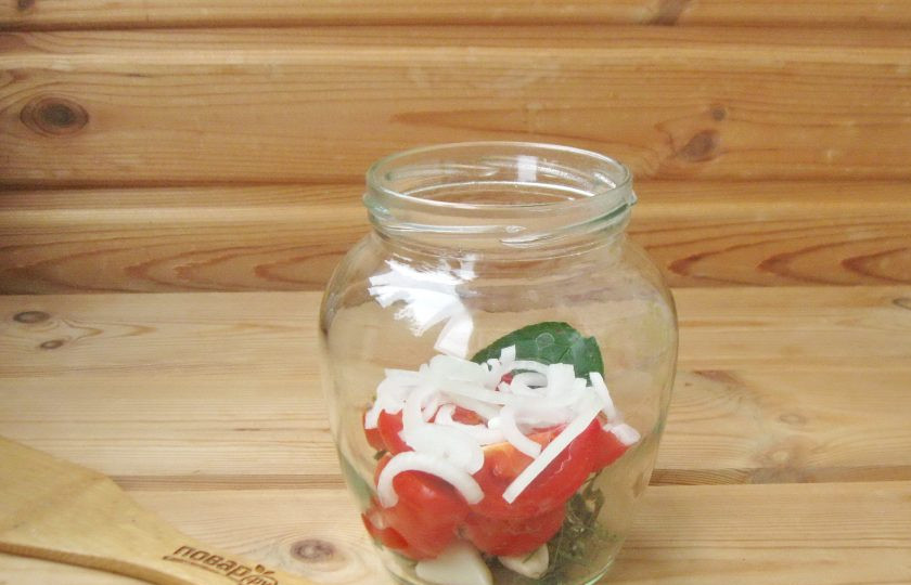 1. Этап. Помидоры кусочками на зиму: Репчатый лук очистите, ополосните и нарежьте полукольцами. Добавьте половину в банку.