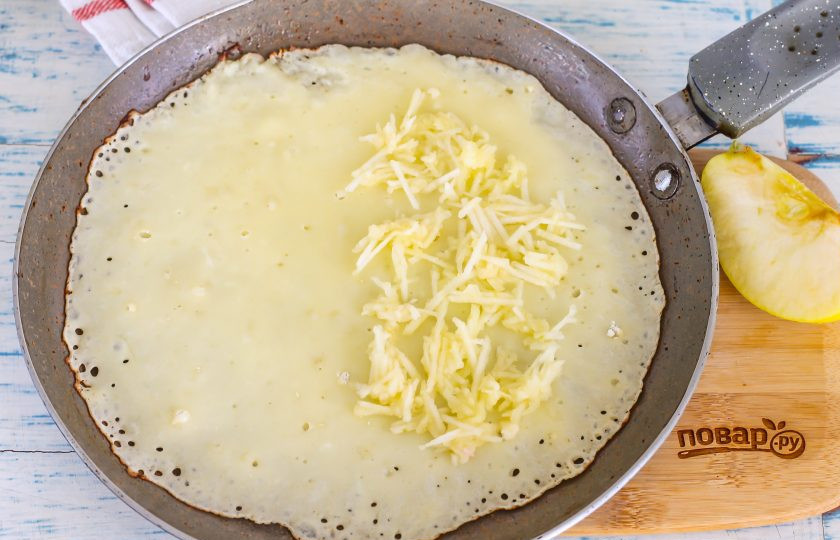 1. Этап. Блины на кефире с припеком: Сразу же, пока тесто не схватилось, выложите часть яблочной нарезки на одну сторону блина. Если сделать это позднее, то яблочная нарезка при прожарке останется на сковороде.