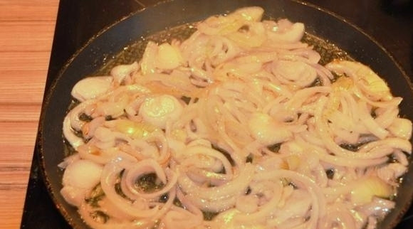 1. Этап. Салат из минтая: Нарезанный полукольцами лук обжариваем на оливковом масле.